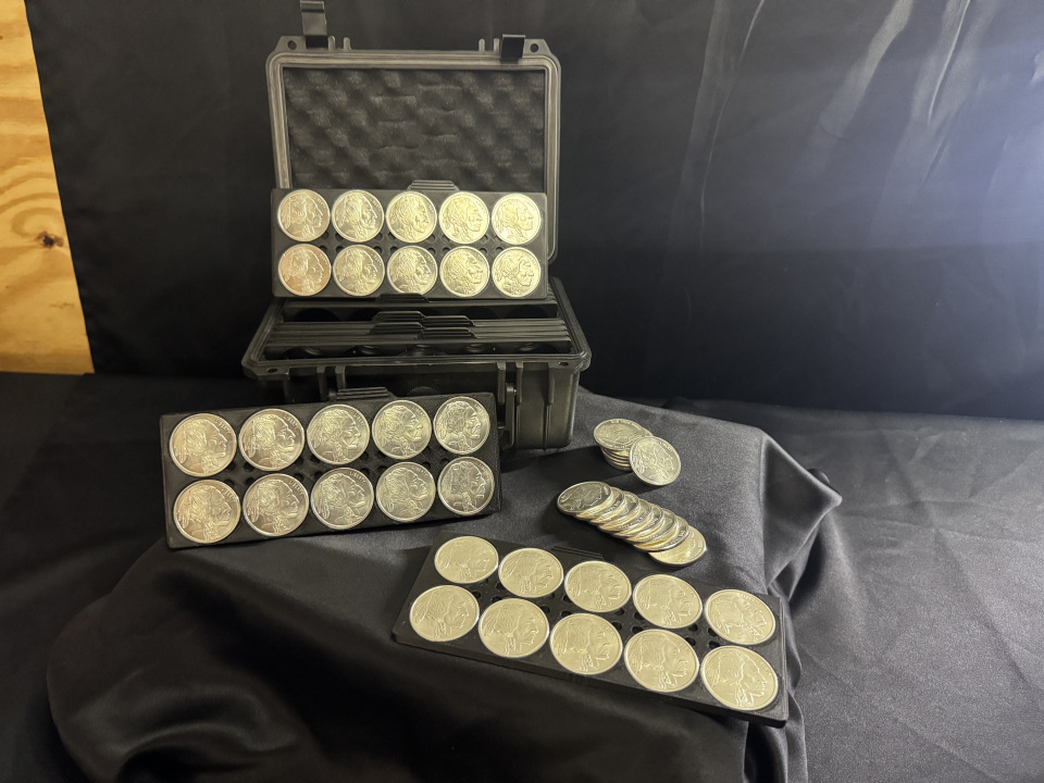 Open case with trays and silver coins displayed on black fabric