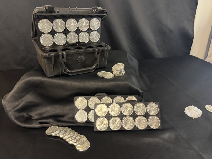 Open case with trays and stacked silver coins from another angle